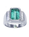 A 18k white gold mens ring with an emerald cut natural colombian emerald bezel set and diamond accents on a topside view and sideways visibles.