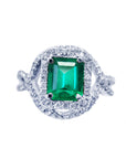 An emerald-cut natural emerald ring full top profile view on a white background.