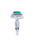 Emerald-cut natural emerald ring with halo diamonds on an 18K white gold split shank band.