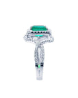 Emerald-cut natural emerald ring with halo diamonds on an 18K white gold split shank band.