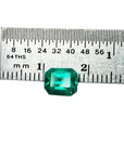 Emerald-cut 1.41 carat natural loose Colombian emerald, medium deep bluish green, shown with a ruler.
