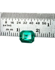Emerald-cut 1.41 carat natural loose Colombian emerald, medium deep bluish green, shown with a ruler.