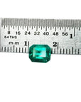 Emerald-cut 1.41 carat natural loose Colombian emerald, medium deep bluish green, shown with a ruler.