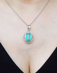 A natural colombian emerald pendant on a person's neck.