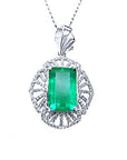 Emerald-cut natural colombian emerald pendant with white gold chain on a topside view position.