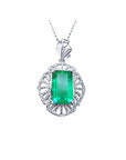 Emerald-cut natural colombian emerald pendant with white gold chain on a topside view position.