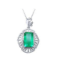 Emerald-cut natural colombian emerald pendant with white gold chain on a topside view position.