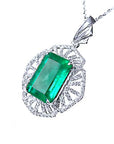 Emerald green gemstone pendant on a white gold chain, topside perspective view.