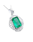 A natural colombian emerald-cut emerald pendant with diamond accents on a white gold design.