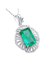 A natural colombian emerald-cut emerald pendant with diamond accents on a white gold design.