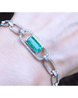 A paperclip bracelet with a natural Colombian emerald accented with diamonds, crafted in 14k white gold on a wist.