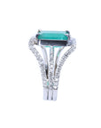This ladies naturales emerald ring is displaying a side top and triple row of diamonds profile.