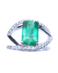 Ring with a rectangular emerald and split shank with diamonds in white gold.