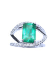 Ring with a rectangular emerald and split shank with diamonds in white gold.