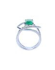 Rectangular emerald-cut emerald ring with diamond double halo and split shank in 14K white gold.