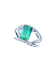 Rectangular emerald-cut emerald ring with double diamond halo and split shank in 14K white gold.