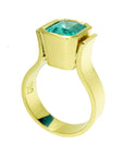 A 14k gold emerald solitaire ring displaying its half side profile.