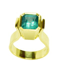 This bezel set solitaire emerald gold ring is made in 14k yellow gold.