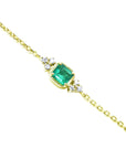 Gold bracelet with a square genuine emerald and small diamonds on a white background