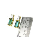 Minimalist 14K gold baguette emerald and diamond stud earrings, shown with a ruler for scale.