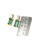 Minimalist 14K gold baguette emerald and diamond stud earrings, shown with a ruler for scale.