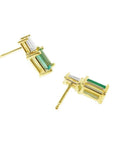Gold stud earrings with baguette emeralds and tapered baguette diamonds.