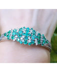 A round cut genuine colombian emerald bangle bracelet natural diamonds crafted in 14k white gold.