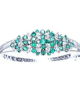 14k white gold bangle bracelet with round Colombian emeralds and diamonds.