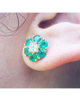 18K yellow gold Colombian emerald and diamond cluster earring on an ear.