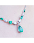 14k white gold necklace with pear-shaped emeralds and diamonds, featuring a large emerald drop pendant.