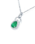 Pear-shaped Colombian emerald and diamond halo pendant in 14K white gold on a delicate chain.