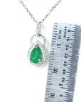 Pear cut colombian emerald and diamond pendant white gold.