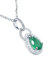 Pear-shaped Colombian emerald and diamond halo pendant in 14K white gold.