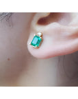 Colombian emerald and diamond stud earring in 14K yellow gold, worn on an ear.