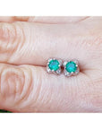 Emerald and diamond tulip stud earrings in 14K white gold, featuring deep bluish-green emeralds.