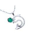 A solid white gold emerald dolphin pendant with natural diamonds.