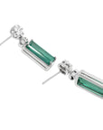 14K white gold dangling earrings with rectangular emeralds and diamond clusters.