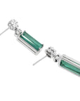 14K white gold dangling earrings with rectangular emeralds and diamond clusters.