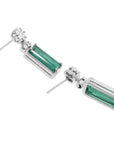 14K white gold dangling earrings with rectangular emeralds and diamond clusters.