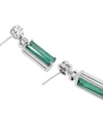 14K white gold dangling earrings with rectangular emeralds and diamond clusters.