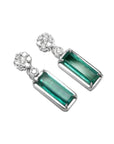Pair of earrings with rectangular emeralds suspended fron a cluster diamond accents 14k white gold.