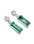 Pair of earrings with rectangular emeralds suspended fron a cluster diamond accents 14k white gold.