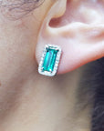 Emerald earring halo diamond in white gold on a woman's ear
