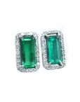 Pair of natural colombian emerald earrings with 18k white gold frames and halo diamond.