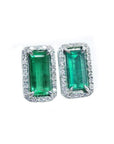 Pair of natural colombian emerald earrings with 18k white gold frames and halo diamond.