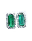 Pair of natural colombian emerald earrings with 18k white gold frames and halo diamond.