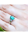 Colombian emerald engagement ring with a 1.09 ct emerald cut medium green emerald and baguette diamonds in 18K white gold.