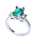 Lateral profile of a natural emerald engagement ring side diamonds in white gold.