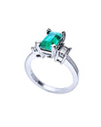 Lateral profile of a natural emerald engagement ring side diamonds in white gold.