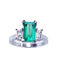 A colombian emerald three stone engagement ring side baguette diamonds made of 18k white gold.
